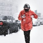 man walking on sidewalk in snow