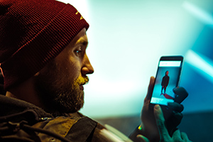 bearded man looking at an image on his smartphone