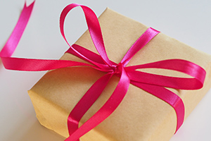 present in brown paper with a pink bow