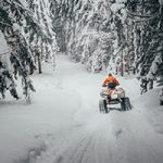 four wheeler on snowy forest road